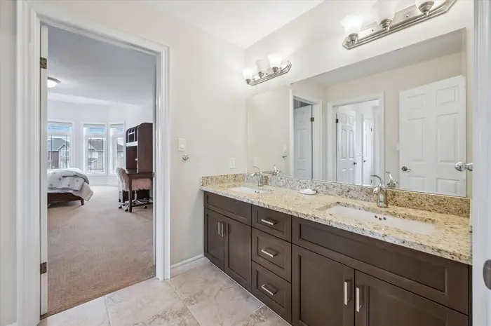 Jack and Jill bathroom with double granite vanity connecting two bedrooms