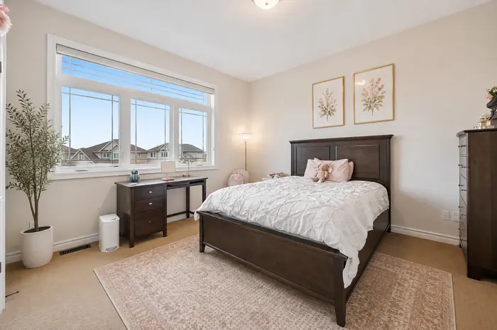Bedroom with desk nook and large window, virtually staged