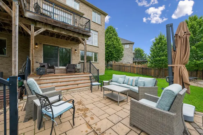Covered patio lounge beneath the deck with walkout access, digitally enhanced image