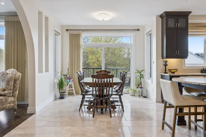 Sunlit dinette with sliding walkout to the rear deck and treed views