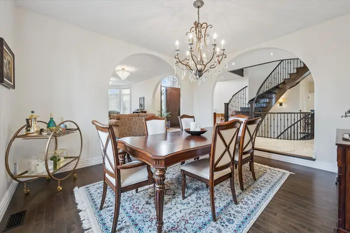 Formal dining room with chandelier and archways to the foyer