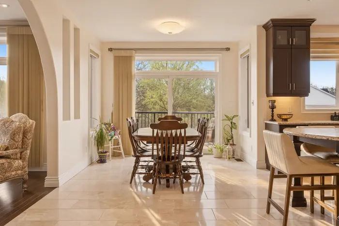 Sunlit dinette with walkout to the deck in golden hour light, AI-enhanced image
