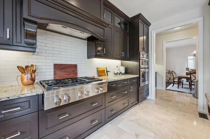 Six-burner gas cooktop with custom range hood and built-in wall ovens