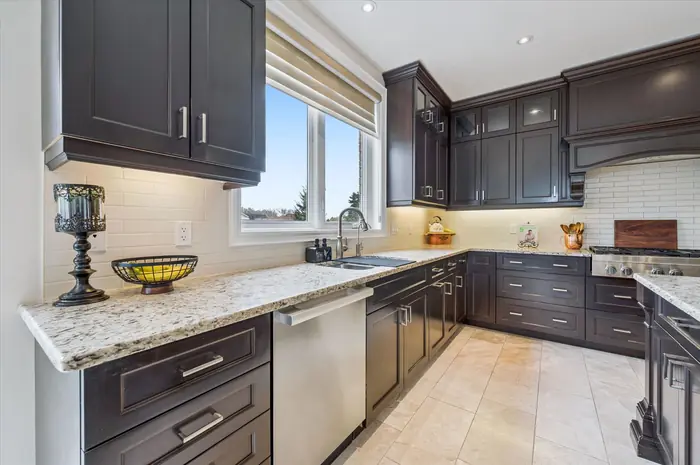 Granite countertops and custom dark cabinetry with under-cabinet lighting
