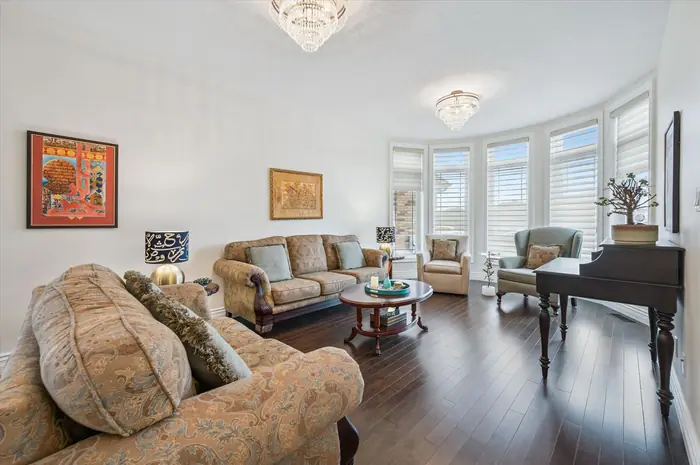 Formal living room with curved bay windows and hardwood floors