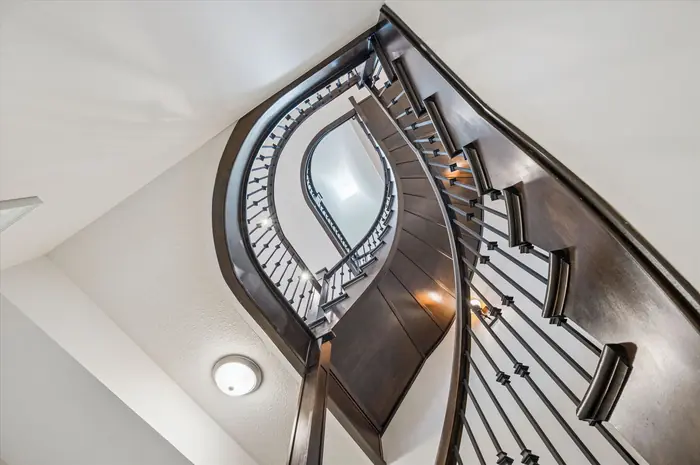Looking up through the curved open staircase to the skylight above