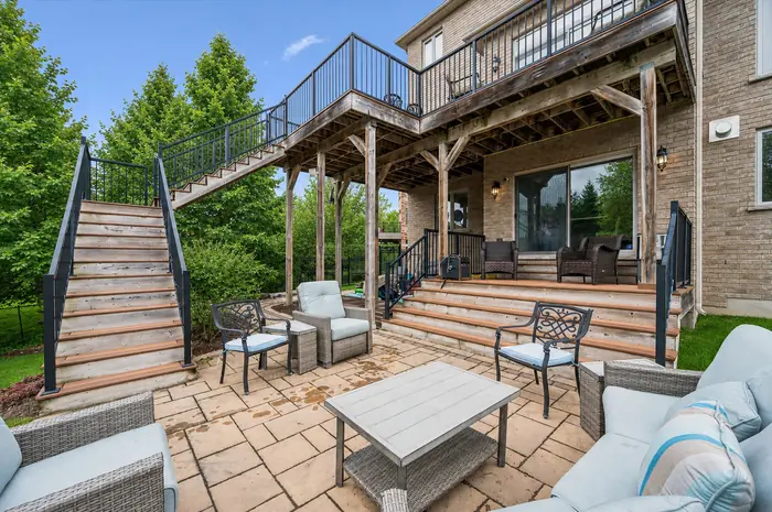 Two-level timber deck with staircase down to the stone patio lounge, digitally enhanced image